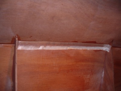  2/28/11 - A piece of fiberglass tape is stuck onto an epoxy fillet on the seam between panels.   